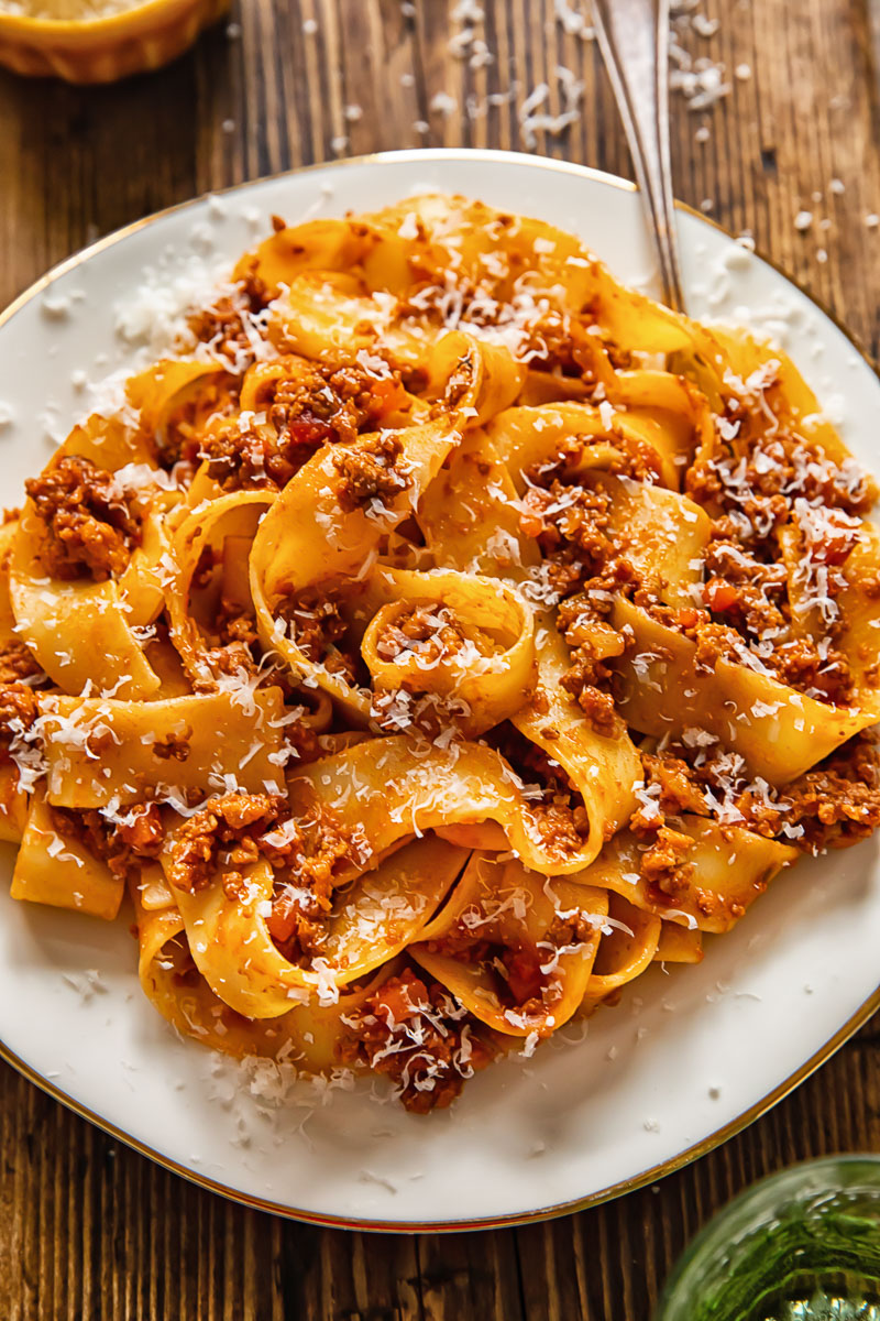 pasta with ragu sauce on a while place and a fork