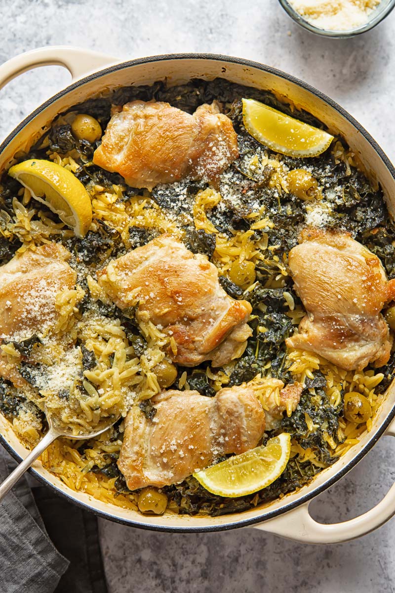 top down view of a round pan with lemon chicken and orzo bake