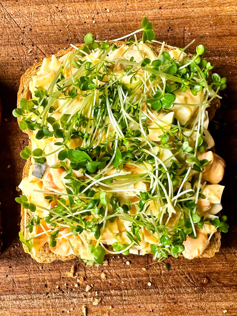 top down view of egg salad and salad cress on top of a bread slice