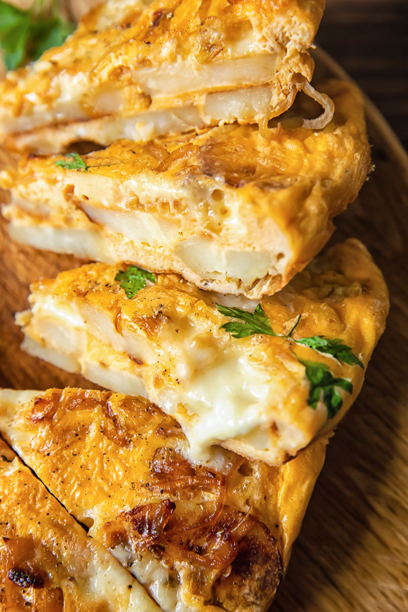 close up of sliced potato frittata with cheese oozing out