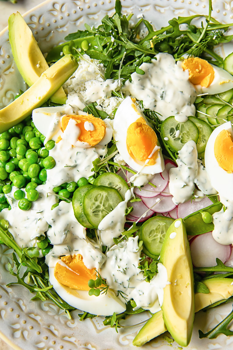 close up of the pea salad with boiled eggs, avocados and arugula
