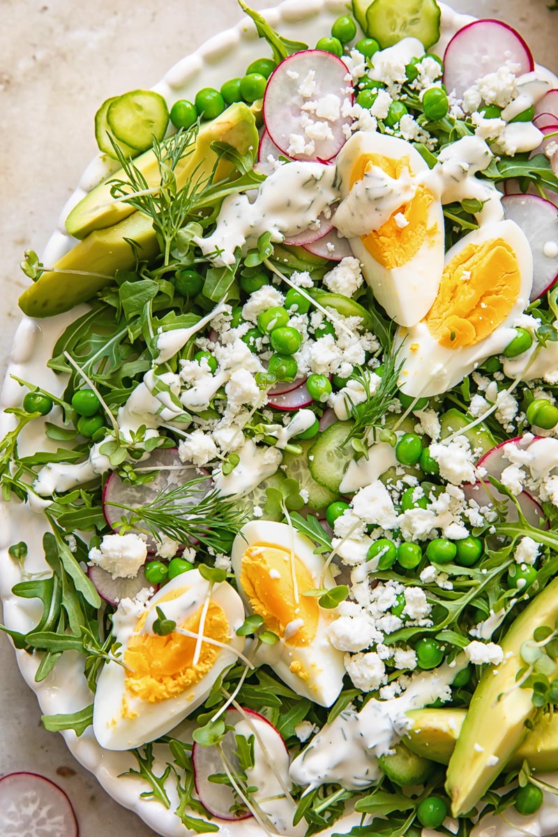 close up of the green pea salad with eggs, rocket and feta