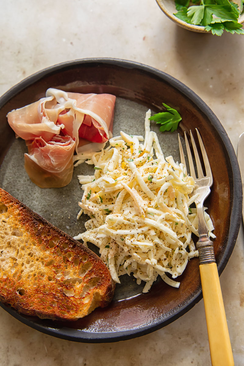 top dow view of a starter plate with celeriac remoulade, toasted sourdough bread and prosciutto