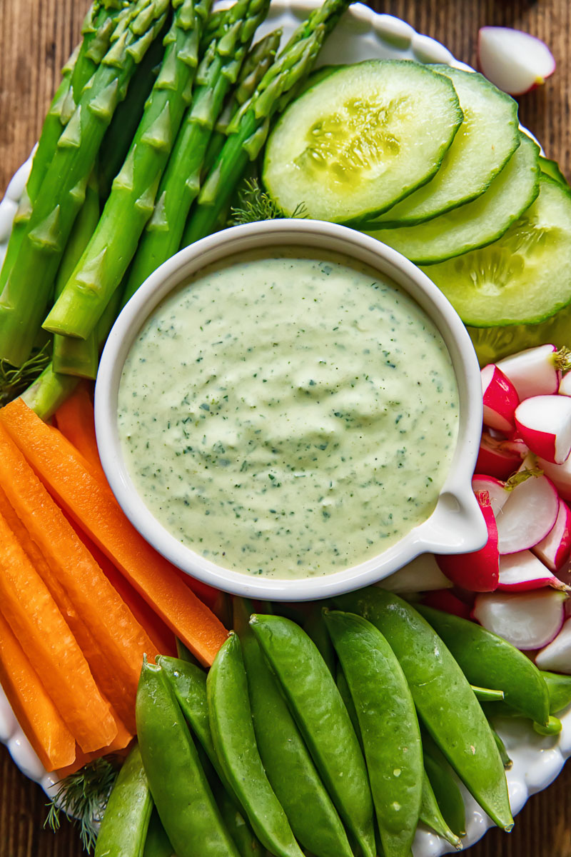 an arrangement of vegetables around a green dip