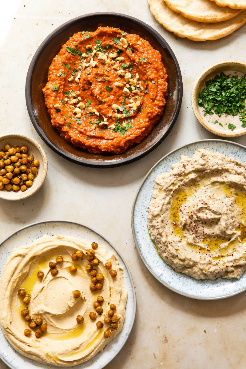 top down view of Middle Eastern spreads on plate, roasted chickpeas in a bowl, chopped parsley in a bowl