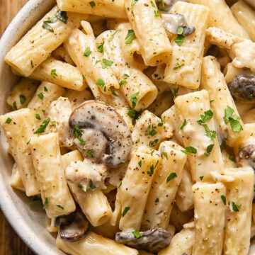 creamy pasta with mushrooms and sausage in a bowl