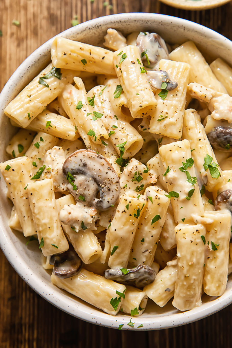 creamy pasta with mushrooms and sausage in a bowl