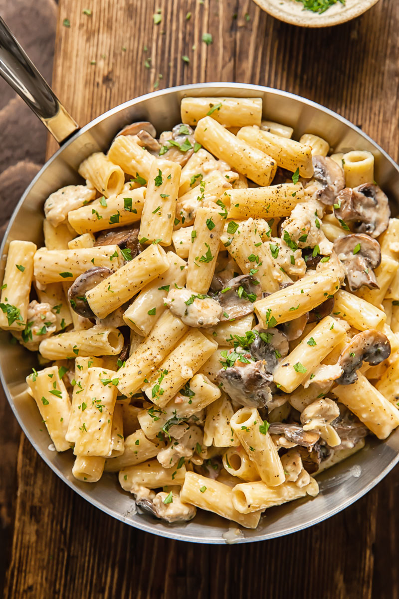 top down view of creamy pasta with sausage and mushrooms in a pan