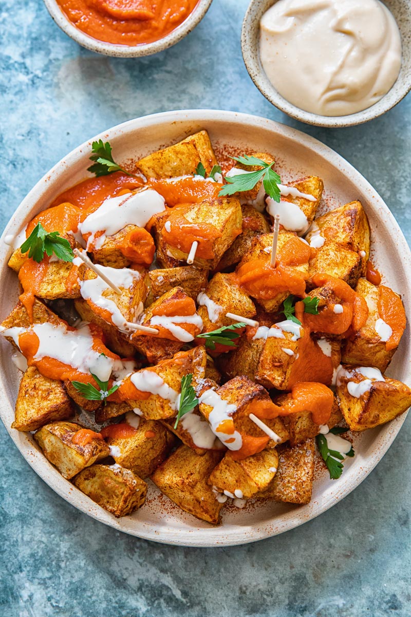 top down view of patatas bravas with the red sauce and alioli