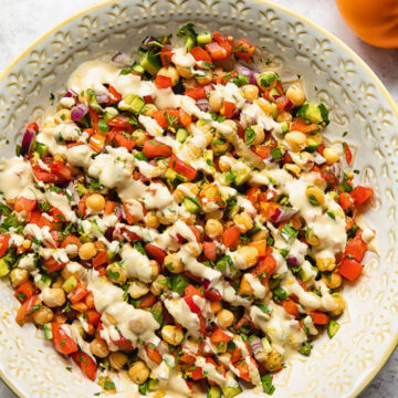 Top down view of Israeli salad with lemon garlic tahini dressing in a bowl