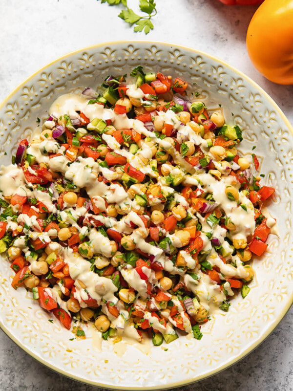 Top down view of Israeli salad with lemon garlic tahini dressing in a bowl