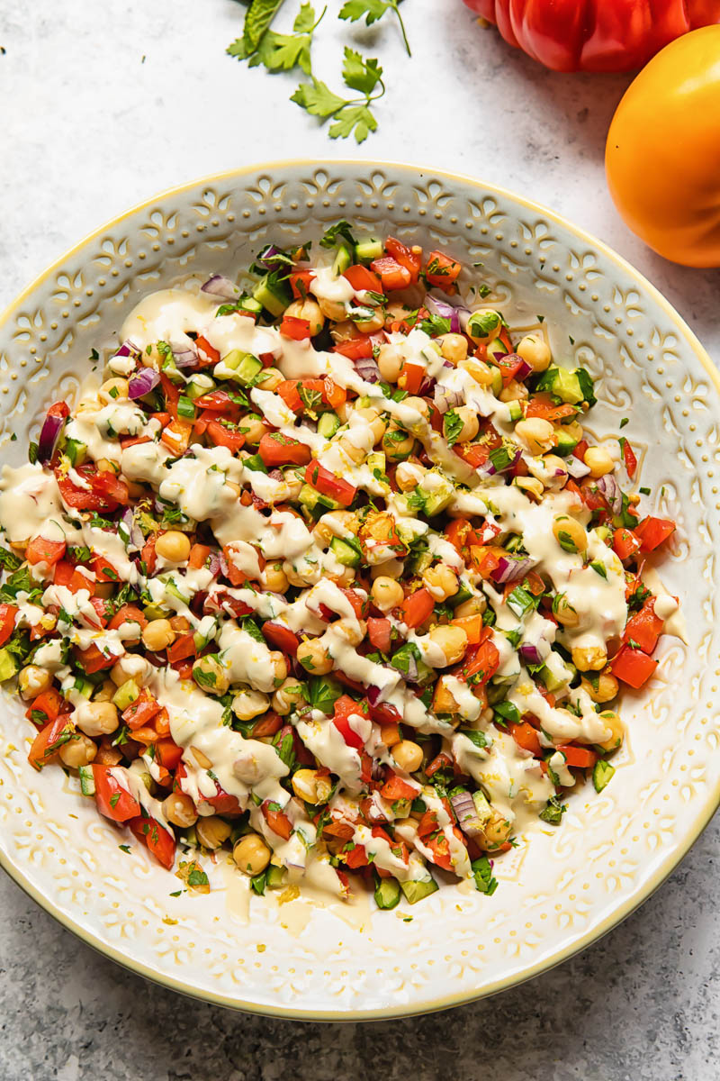 Top down view of Israeli salad with lemon garlic tahini dressing in a bowl