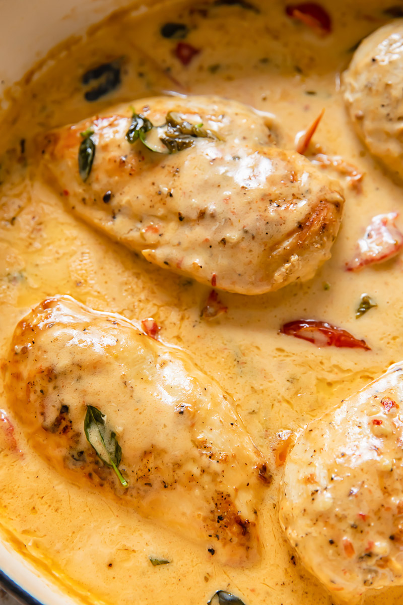 Close up shot of chicken breast in marry me sauce in a pan