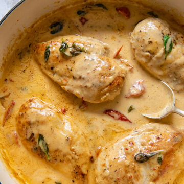 Top down view of chicken breast in creamy tomato sauce in a pan