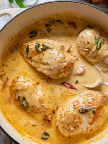 Top down view of chicken breast in creamy tomato sauce in a pan