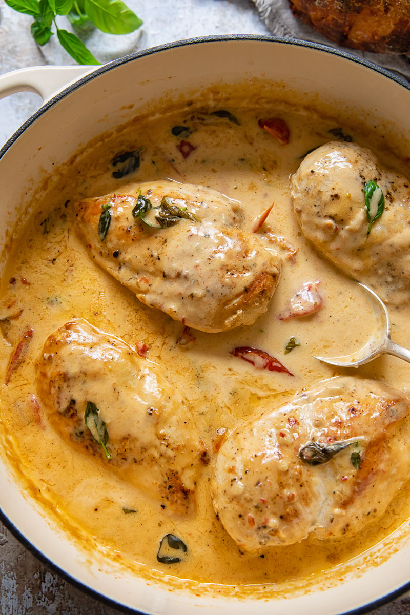 Top down view of chicken breast in creamy tomato sauce in a pan