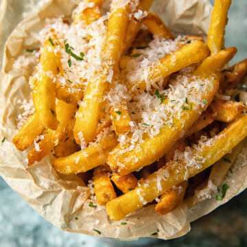 Top down view of truffle fries in a bowl sprinkled with parmesan