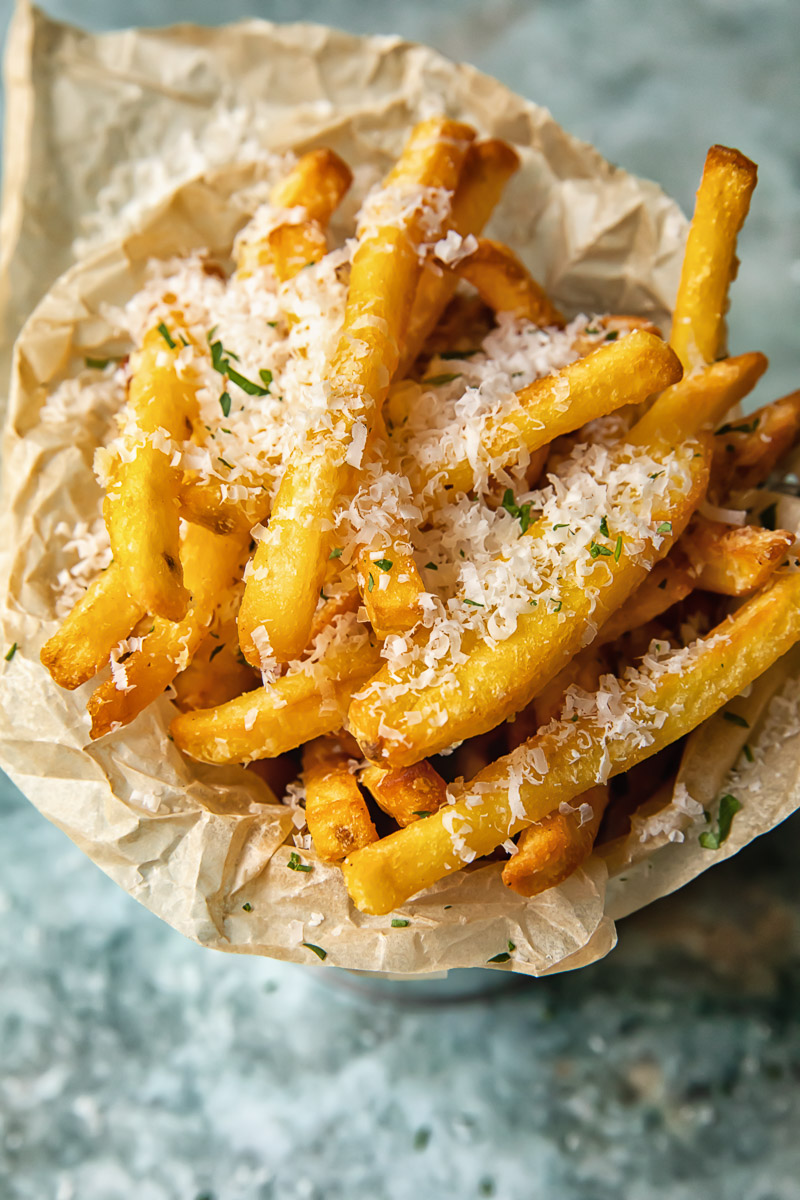 Top down view of truffle fries in a bowl sprinkled with parmesan