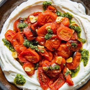 top down view of ricotta dipped topped with roasted cherry tomatoes and pesto