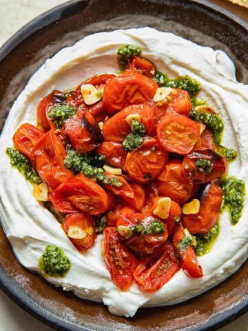 top down view of ricotta dipped topped with roasted cherry tomatoes and pesto