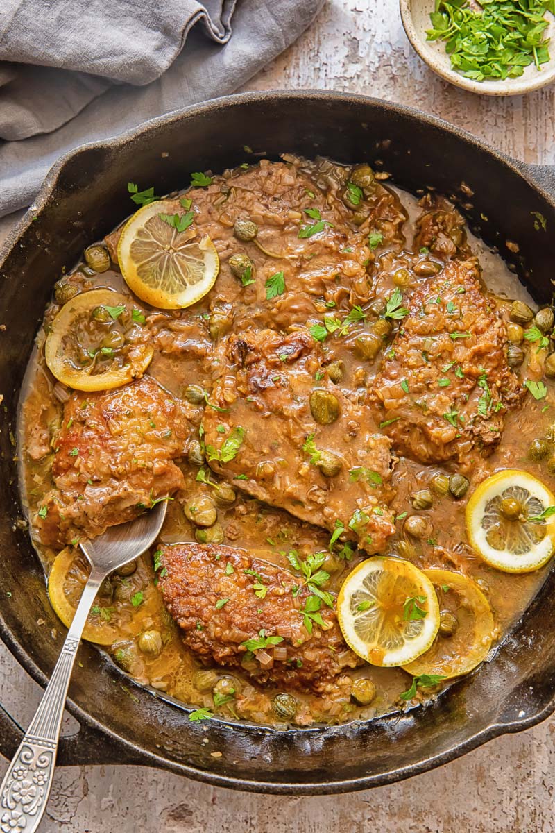 top down view of veal cutlets in lemon caper sauce