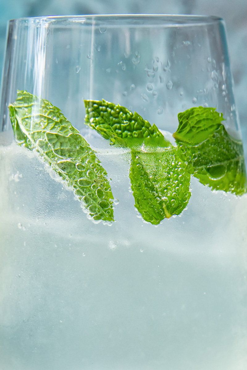 Close up shot of mint leaves in a glass of mojito