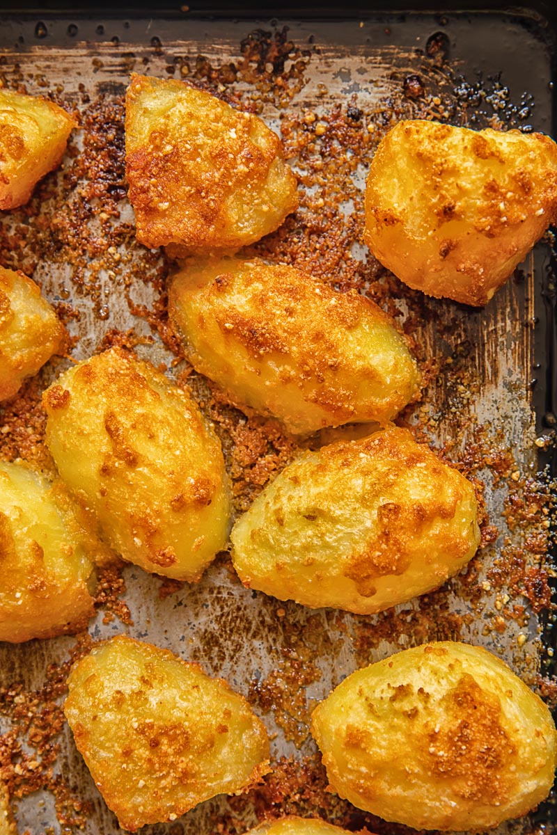 Top down shot of parmesan crusted potatoes on a baking tray