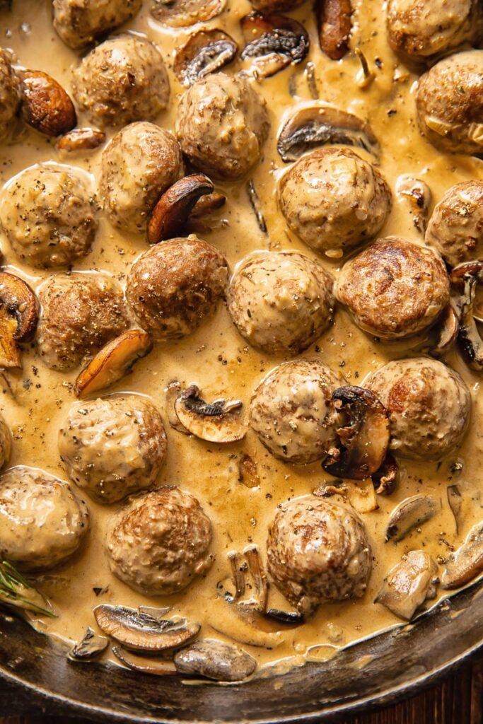 Close up shot of meatballs in Marsala sauce with mushrooms
