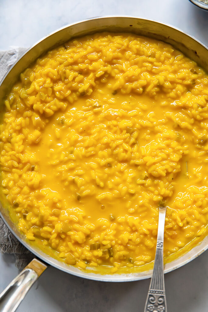 top down view of a pan of yellow saffron risotto