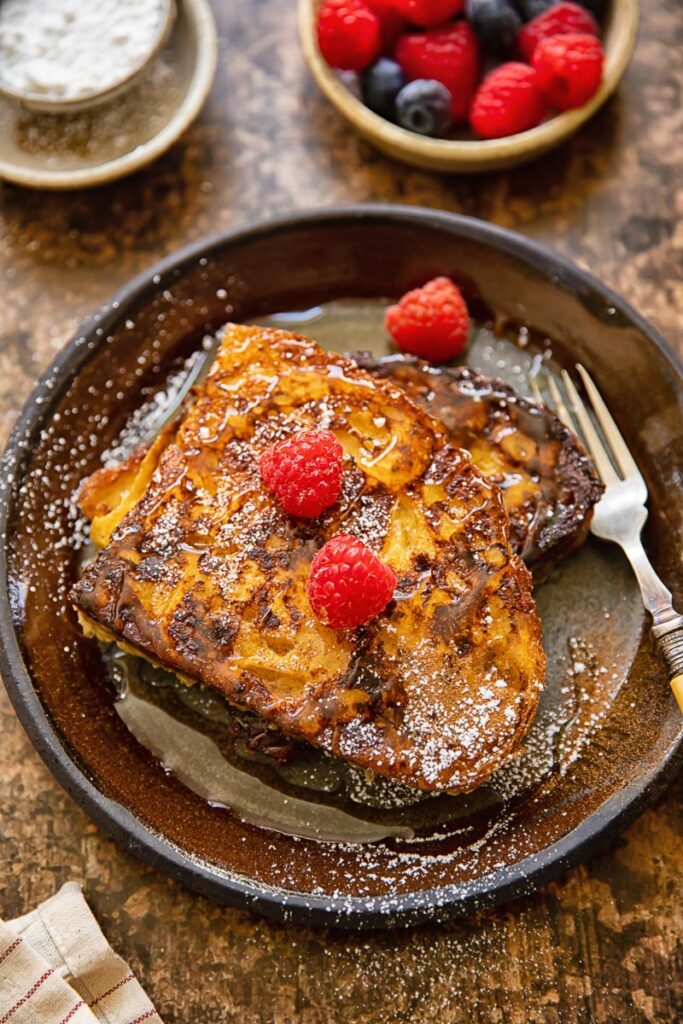 Top down view of raspberries of sourdough French toast on a plate