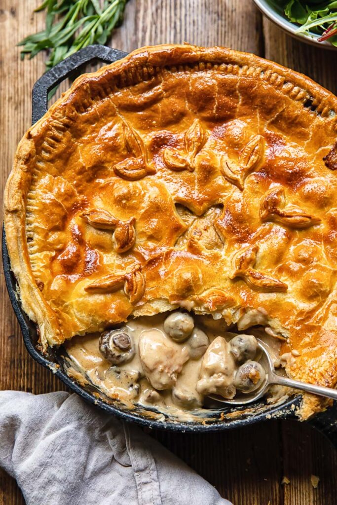 Chicken and mushroom pie with slice removed and creamy insides showing
