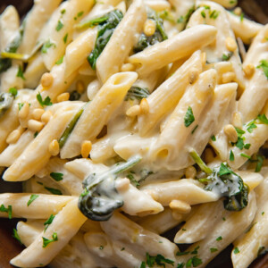 plate of goat cheese pasta with parsley and pine nuts sprinkled on top