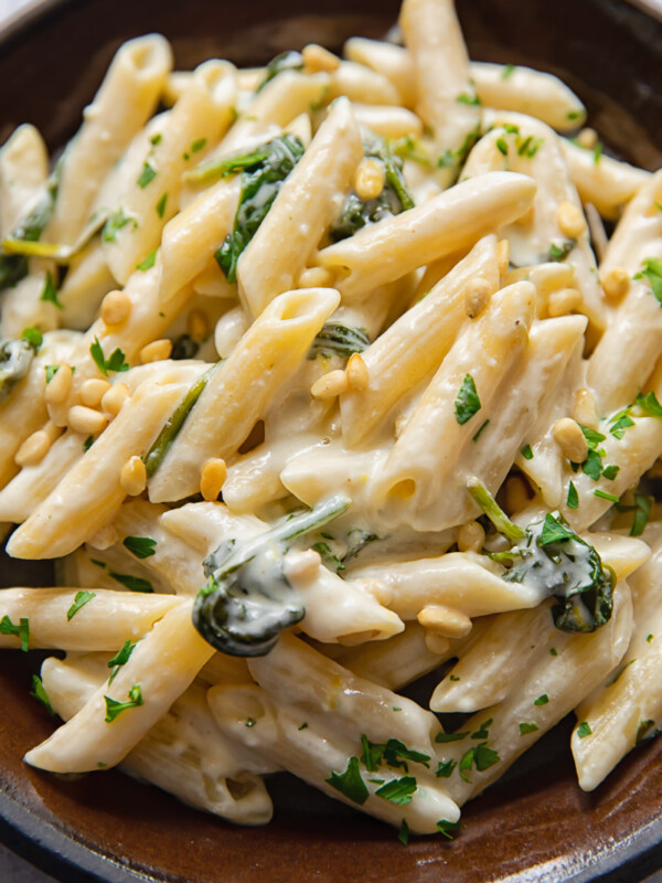plate of goat cheese pasta with parsley and pine nuts sprinkled on top
