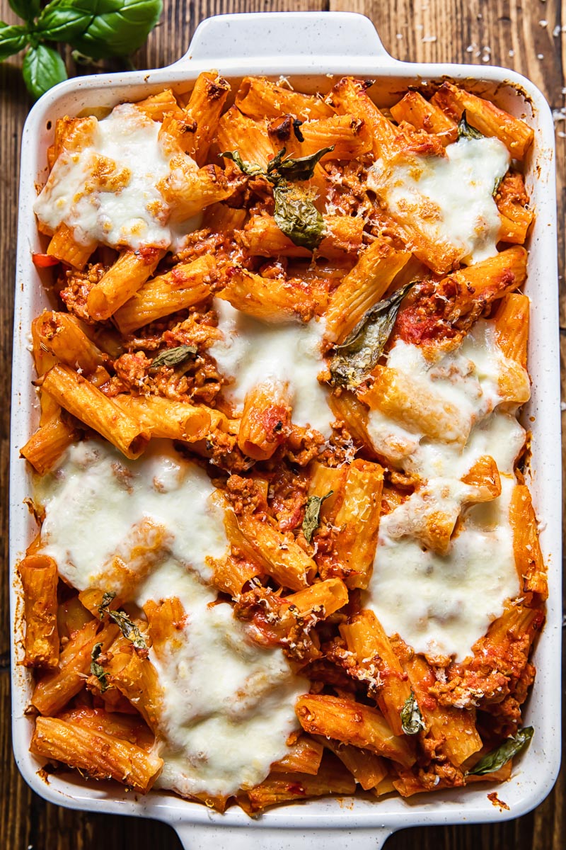 Top down view of pasta al forno topped with melted cheese is a baking dish