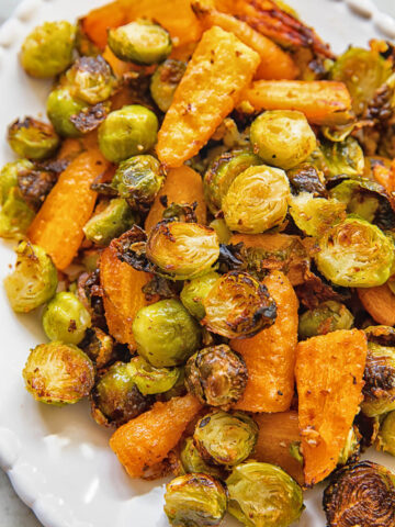 close up of a serving plate with roasted brussels sprouts and carrots