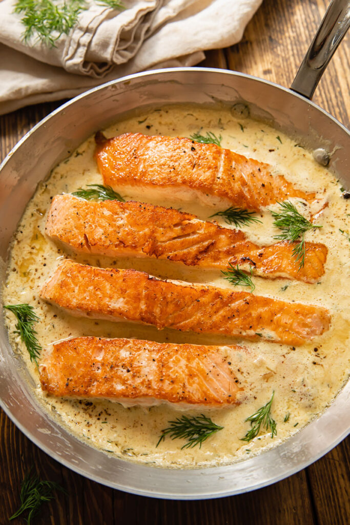 four pieces of salmon in creamy lemon dill sauce