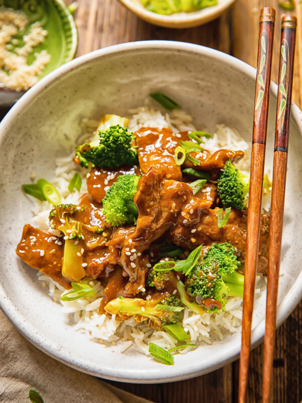 bowl of beef and broccoli stir fry with chop sticks