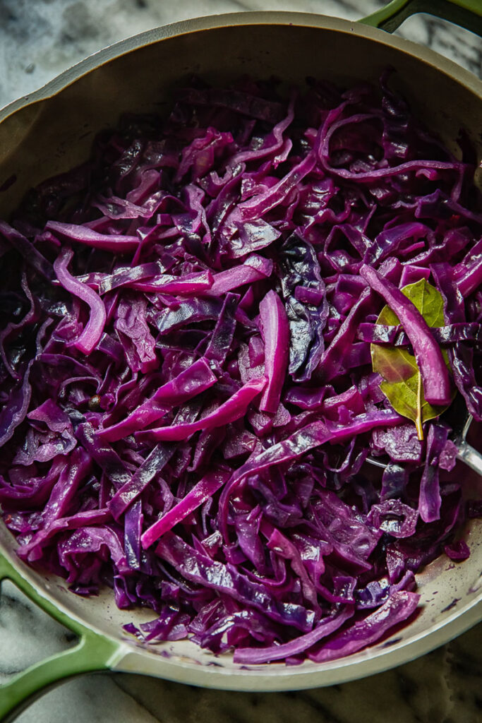 Close up view of braised red cabbage being cooked in a large pan