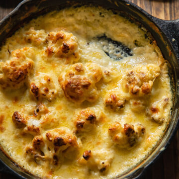 Close up shot of cauliflower florets in a pan with Mornay sauce