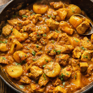 Top down view of chicken curry in a pan with potatoes