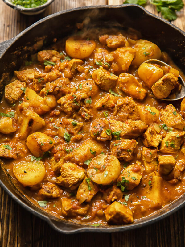Top down view of chicken curry in a pan with potatoes