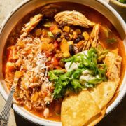 Top down view of chicken tortilla sop with rice, beans, corn and green onions in a bowl