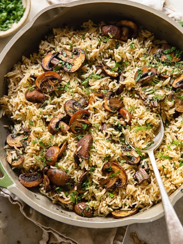 Top down view of mushroom rice in a pot topped with fresh parsley