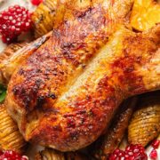 Close up shot of roasted duck on a platter with cranberries and potatoes
