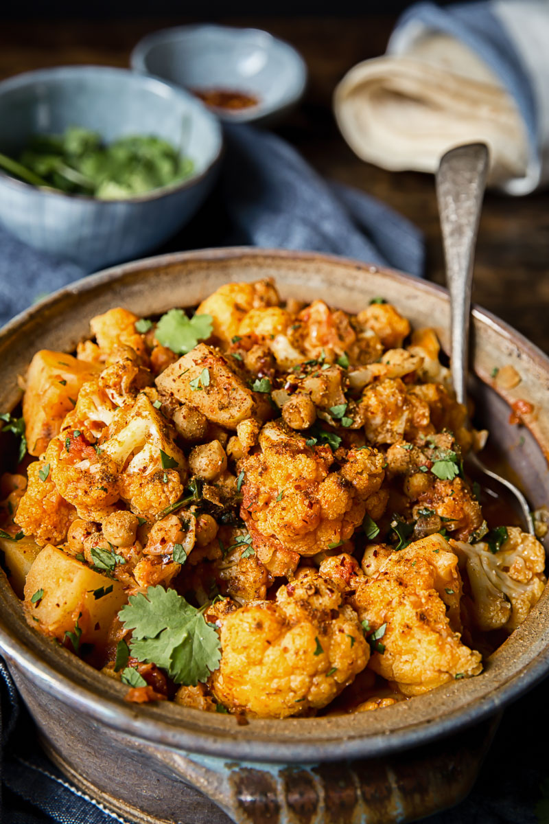 close up of cauliflower and potato curry in a clay pot