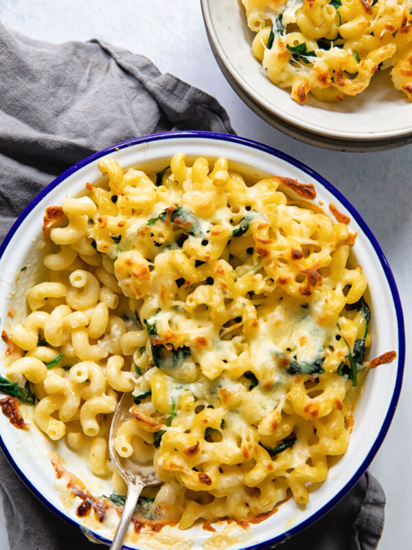 Top down view of baked brie mac and cheese with a spoon and serving dish