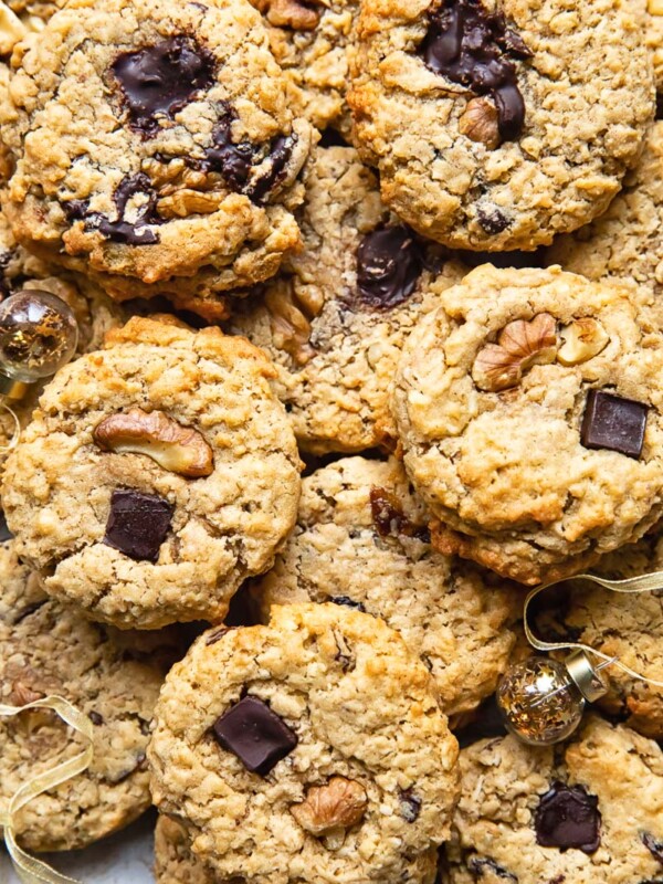 Top down shot of many cowboy cookies stacked on top of each other on a cutting board