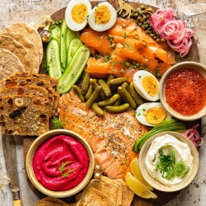 Top down view of grazing board made of smoked salmon, cucumbers, pickles and capers