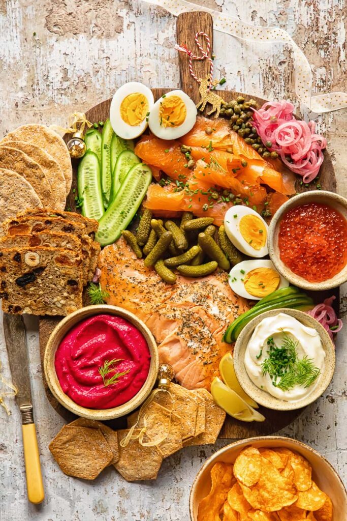 Top down view of grazing board made of smoked salmon, cucumbers, pickles and capers