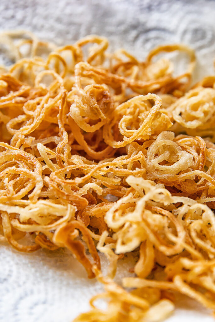Close up shot of crispy caramelised onions stacked on top of each other on a towel